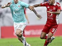 Roger Krug Guedes (L) of Al Rayyan SC battles for the ball with Jassem Gaber Abdulsallam (R) of Al Arabi SC during the Ooredoo Qatar Stars L...