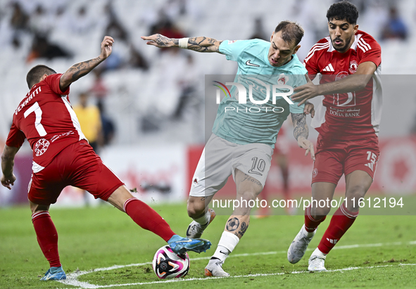 Roger Krug Guedes (R) of Al Rayyan SC battles for the ball with Jassem Gaber Abdulsallam (C) of Al Arabi SC during the Ooredoo Qatar Stars L...