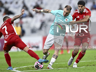 Roger Krug Guedes (R) of Al Rayyan SC battles for the ball with Jassem Gaber Abdulsallam (C) of Al Arabi SC during the Ooredoo Qatar Stars L...