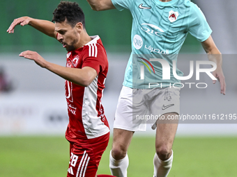 Julien De Sart (R) of Al Rayyan SC battles for the ball with Youssef Msakni (L) of Al Arabi SC during the Ooredoo Qatar Stars League 24/25 m...