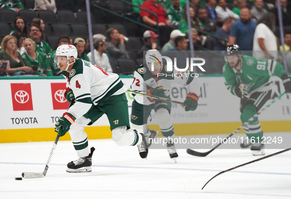 Jon Merril #4 of the Minnesota Wild controls the puck during the NHL preseason match between the Dallas Stars and the Minnesota Wild at Amer...