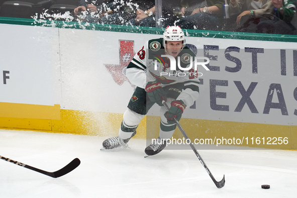 Marco Rossi #23 of the Minnesota Wild skates up the ice while controlling the puck during the NHL preseason match between the Dallas Stars a...