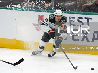 Marco Rossi #23 of the Minnesota Wild skates up the ice while controlling the puck during the NHL preseason match between the Dallas Stars a...