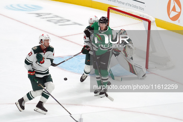 Oskar Back #10 of the Dallas Stars plays the puck in front of Filip Gustavsson #32 of the Minnesota Wild at the net during the NHL preseason...