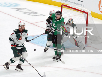 Oskar Back #10 of the Dallas Stars plays the puck in front of Filip Gustavsson #32 of the Minnesota Wild at the net during the NHL preseason...