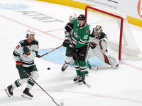 Oskar Back #10 of the Dallas Stars plays the puck in front of Filip Gustavsson #32 of the Minnesota Wild at the net during the NHL preseason...