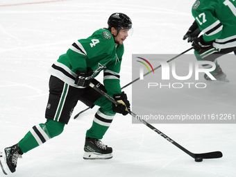 Miro Heiskanen #4 of the Dallas Stars skates up the ice while controlling the puck during the NHL preseason match between the Dallas Stars a...