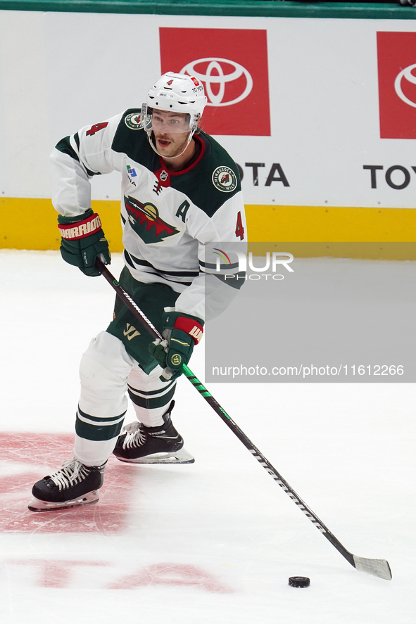 Jon Merrill #4 of the Minnesota Wild controls the puck during the NHL preseason match between the Dallas Stars and the Minnesota Wild at Ame...