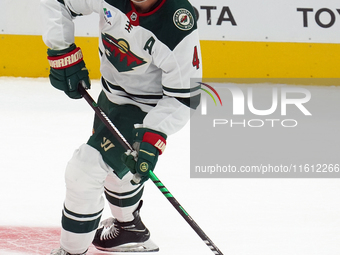 Jon Merrill #4 of the Minnesota Wild controls the puck during the NHL preseason match between the Dallas Stars and the Minnesota Wild at Ame...