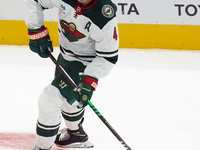 Jon Merrill #4 of the Minnesota Wild controls the puck during the NHL preseason match between the Dallas Stars and the Minnesota Wild at Ame...