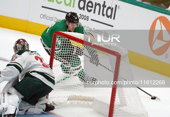 Roope Hintz #24 of the Dallas Stars skates with the puck while trying to evade the goalkeeper from behind the goal during the NHL preseason...