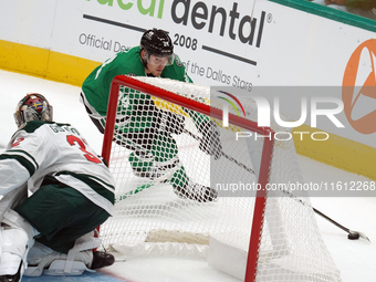 Roope Hintz #24 of the Dallas Stars skates with the puck while trying to evade the goalkeeper from behind the goal during the NHL preseason...