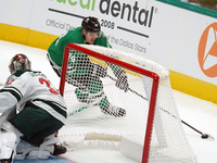 Roope Hintz #24 of the Dallas Stars skates with the puck while trying to evade the goalkeeper from behind the goal during the NHL preseason...