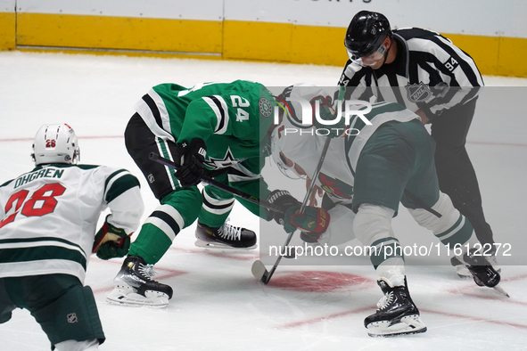 Roope Hintz #24 of the Dallas Stars and Brock Faber #7 of the Minnesota Wild line up against one another during a face-off during the NHL pr...