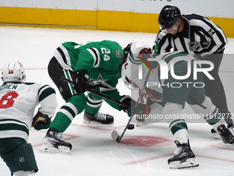 Roope Hintz #24 of the Dallas Stars and Brock Faber #7 of the Minnesota Wild line up against one another during a face-off during the NHL pr...