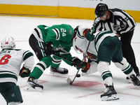 Roope Hintz #24 of the Dallas Stars and Brock Faber #7 of the Minnesota Wild line up against one another during a face-off during the NHL pr...