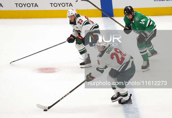 Marco Rossi #23 and Liam Ohgren #28 of the Minnesota Wild defend the puck during the NHL preseason match between the Dallas Stars and the Mi...