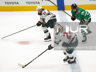 Marco Rossi #23 and Liam Ohgren #28 of the Minnesota Wild defend the puck during the NHL preseason match between the Dallas Stars and the Mi...