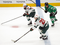 Marco Rossi #23 and Liam Ohgren #28 of the Minnesota Wild defend the puck during the NHL preseason match between the Dallas Stars and the Mi...