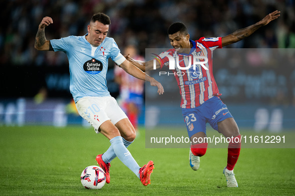 Iago Aspas (L) of RC Celta de Vigo fights for the ball with Reinildo Mandava (R) of Atletico de Madrid during the LaLIGA EA SPORTS match bet...