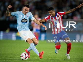 Iago Aspas (L) of RC Celta de Vigo fights for the ball with Reinildo Mandava (R) of Atletico de Madrid during the LaLIGA EA SPORTS match bet...