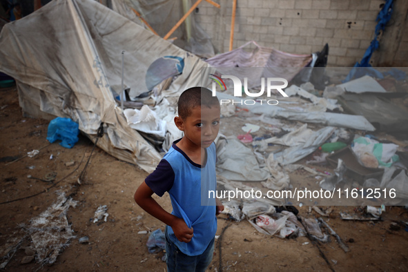 A young boy stands amidst the destruction after a reported overnight Israeli strike that hits tents used as temporary shelters by displaced...