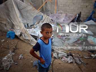 A young boy stands amidst the destruction after a reported overnight Israeli strike that hits tents used as temporary shelters by displaced...