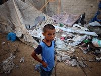 A young boy stands amidst the destruction after a reported overnight Israeli strike that hits tents used as temporary shelters by displaced...