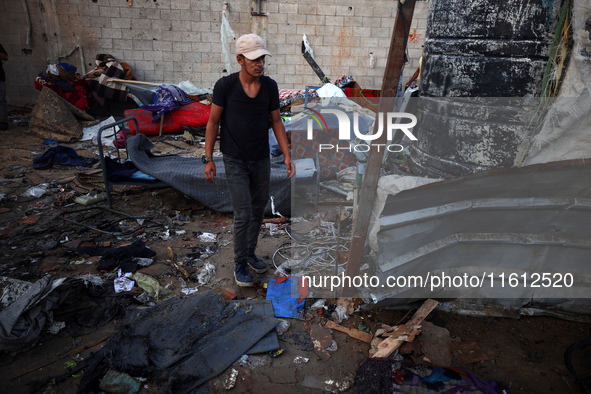 A man stands amidst the destruction after a reported overnight Israeli strike that hits tents used as temporary shelters by displaced Palest...