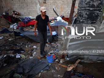 A man stands amidst the destruction after a reported overnight Israeli strike that hits tents used as temporary shelters by displaced Palest...