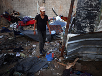 A man stands amidst the destruction after a reported overnight Israeli strike that hits tents used as temporary shelters by displaced Palest...