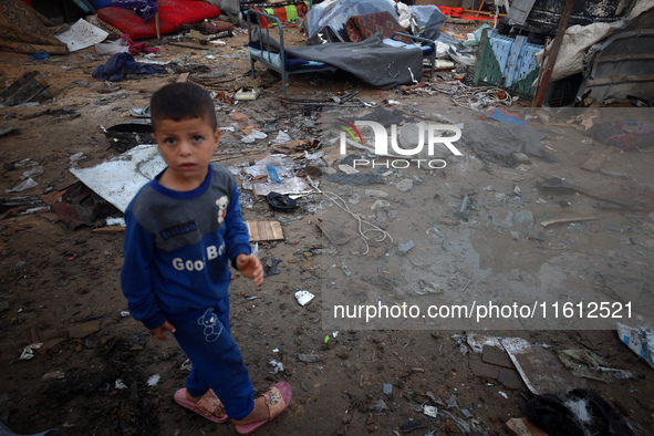 A young boy stands amidst the destruction after a reported overnight Israeli strike that hits tents used as temporary shelters by displaced...