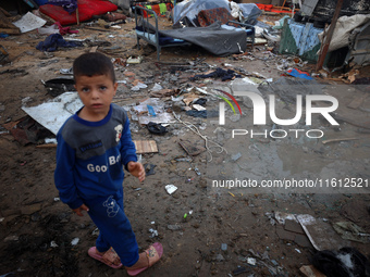 A young boy stands amidst the destruction after a reported overnight Israeli strike that hits tents used as temporary shelters by displaced...