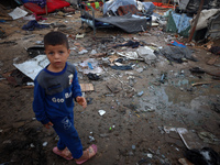 A young boy stands amidst the destruction after a reported overnight Israeli strike that hits tents used as temporary shelters by displaced...