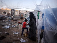 People stand amidst the destruction after a reported overnight Israeli strike that hits tents used as temporary shelters by displaced Palest...