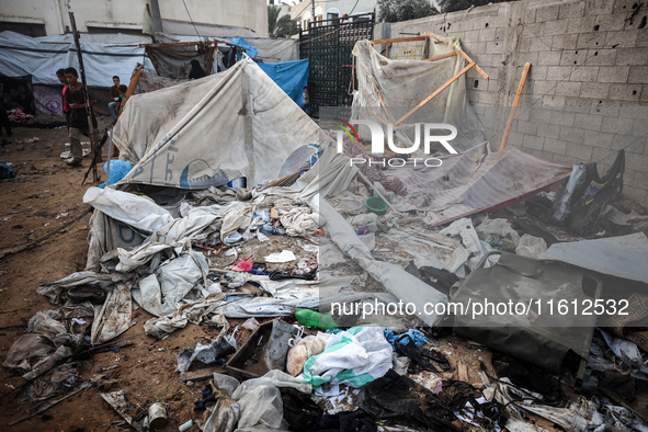 People stand amidst the destruction after a reported overnight Israeli strike that hits tents used as temporary shelters by displaced Palest...