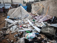 People stand amidst the destruction after a reported overnight Israeli strike that hits tents used as temporary shelters by displaced Palest...