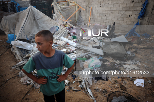 A young boy stands amidst the destruction after a reported overnight Israeli strike that hits tents used as temporary shelters by displaced...