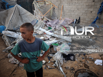 A young boy stands amidst the destruction after a reported overnight Israeli strike that hits tents used as temporary shelters by displaced...