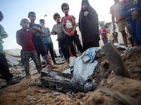 Children stand in the midst of the destruction in the aftermath of a reported overnight Israeli strike that hits tents used as temporary she...