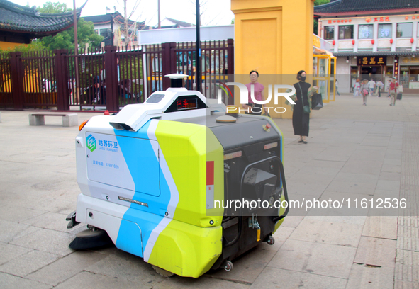 An intelligent sweeping robot works at Xuanmiaiguan Square on Guanqian Street in Suzhou, China, on September 27, 2024. 