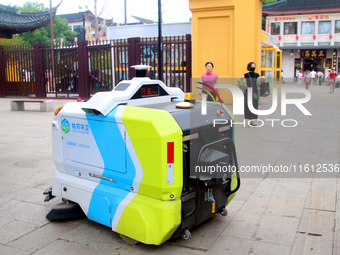 An intelligent sweeping robot works at Xuanmiaiguan Square on Guanqian Street in Suzhou, China, on September 27, 2024. (