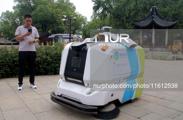 An intelligent sweeping robot works at Xuanmiaiguan Square on Guanqian Street in Suzhou, China, on September 27, 2024. 