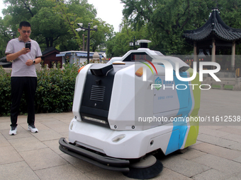 An intelligent sweeping robot works at Xuanmiaiguan Square on Guanqian Street in Suzhou, China, on September 27, 2024. (