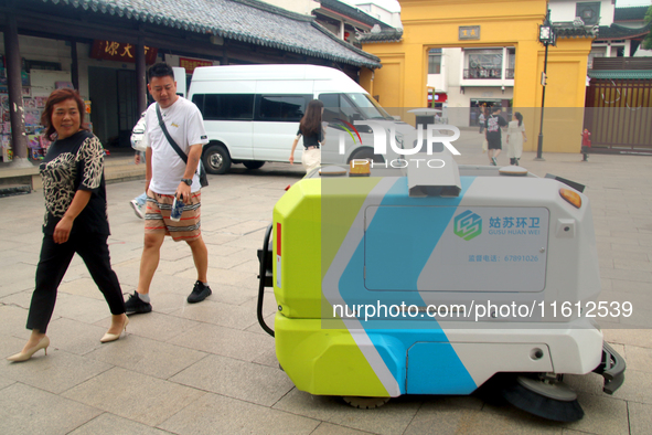 An intelligent sweeping robot works at Xuanmiaiguan Square on Guanqian Street in Suzhou, China, on September 27, 2024. 