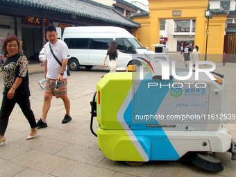 An intelligent sweeping robot works at Xuanmiaiguan Square on Guanqian Street in Suzhou, China, on September 27, 2024. (