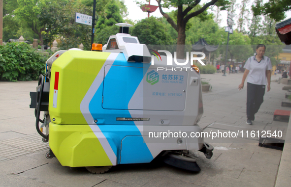 An intelligent sweeping robot works at Xuanmiaiguan Square on Guanqian Street in Suzhou, China, on September 27, 2024. 