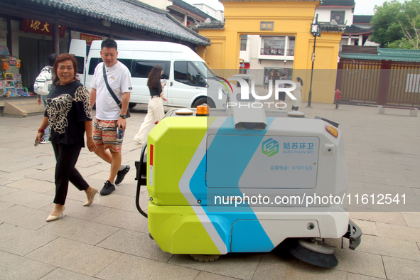 An intelligent sweeping robot works at Xuanmiaiguan Square on Guanqian Street in Suzhou, China, on September 27, 2024. 