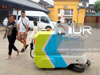 An intelligent sweeping robot works at Xuanmiaiguan Square on Guanqian Street in Suzhou, China, on September 27, 2024. (