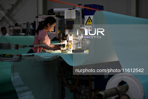 A worker produces paper-making nets at Pacific Special Nets Co., LTD in Fuyang, China, on September 27, 2024. 